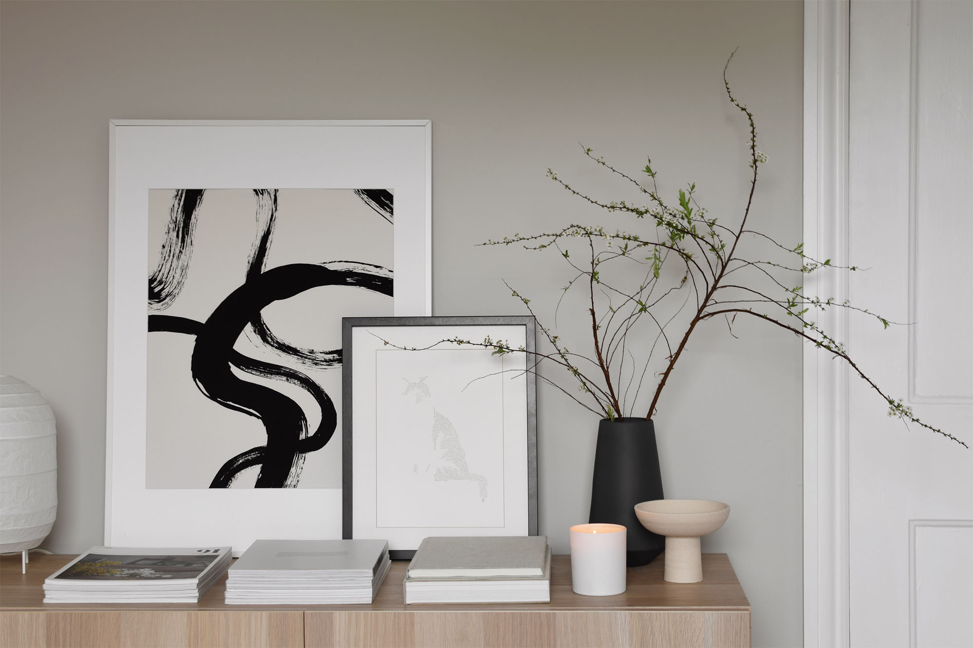Neutral interior with blossom branches, minimalist sideboard styling, soft grey-green walls and abstract art | The best scented candles for spring | These Four Walls blog