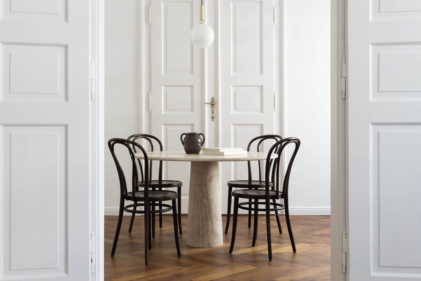 Minimalist dining room featuring Thonet chairs and circular marble table by Rebecca Goddard | These Four Walls blog