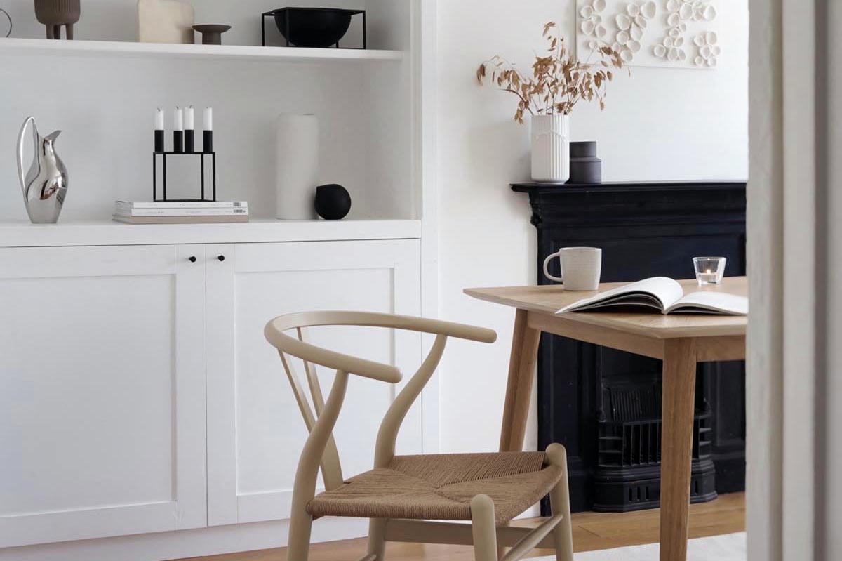 White Scandinavian-style dining room with minimalist shelving display and beige Wishbone chair | Hans J' Wegner's iconic CH24 chair gets an Ilse Crawford makeover | These Four Walls blog