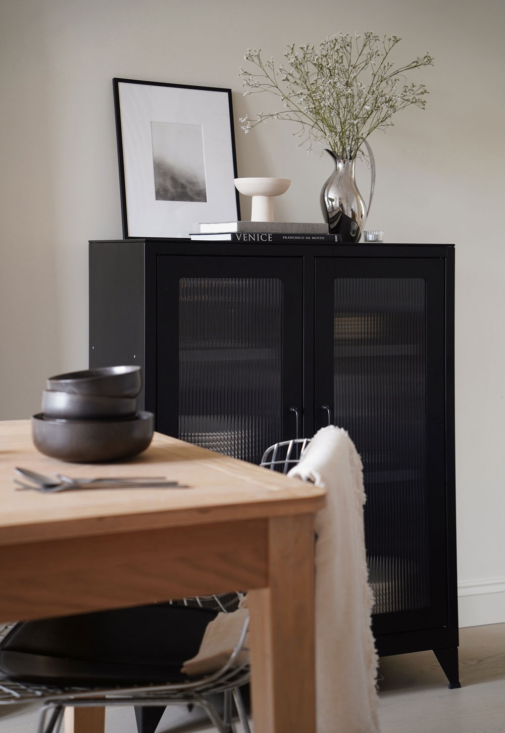 Black reed-fronted display cabinet from Bisley, with rustic-minimalist beige tableware and glassware inside | These Four Walls blog