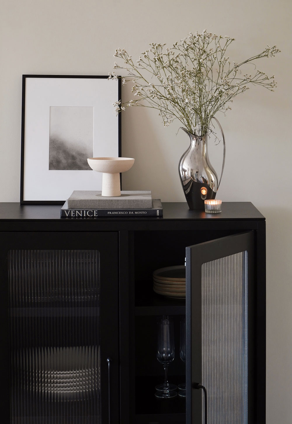 Black reed-fronted display cabinet from Bisley, with rustic-minimalist beige tableware and glassware inside | These Four Walls blog