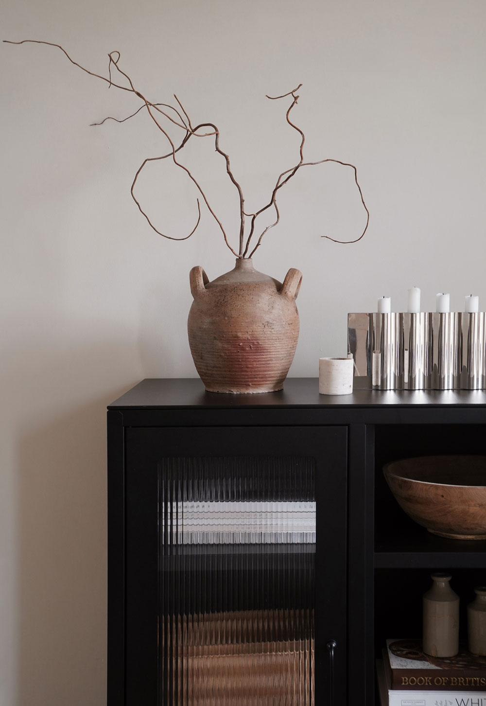 Black reed-fronted display cabinet from Bisley with rustic-minimalist styling and terracotta vase filled with branches | These Four Walls blog