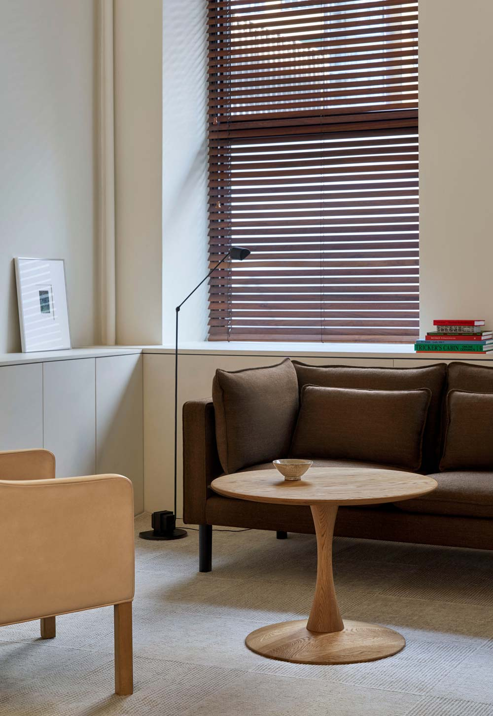 Minimalist living room with brown sofa, built-in storage cabinets and circular oak coffee table from Frederica's 'Trisse' collection, designed by Nanna Ditzel | New design finds - July 2026 | These Four Walls blog