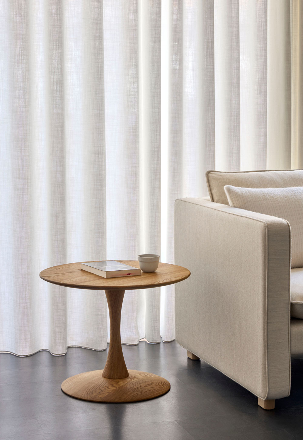 Minimalist living rom with beige sofa and circular oak side table from Frederica's 'Trisse' collection, designed by Nanna Ditzel | New design finds - July 2026 | These Four Walls blog