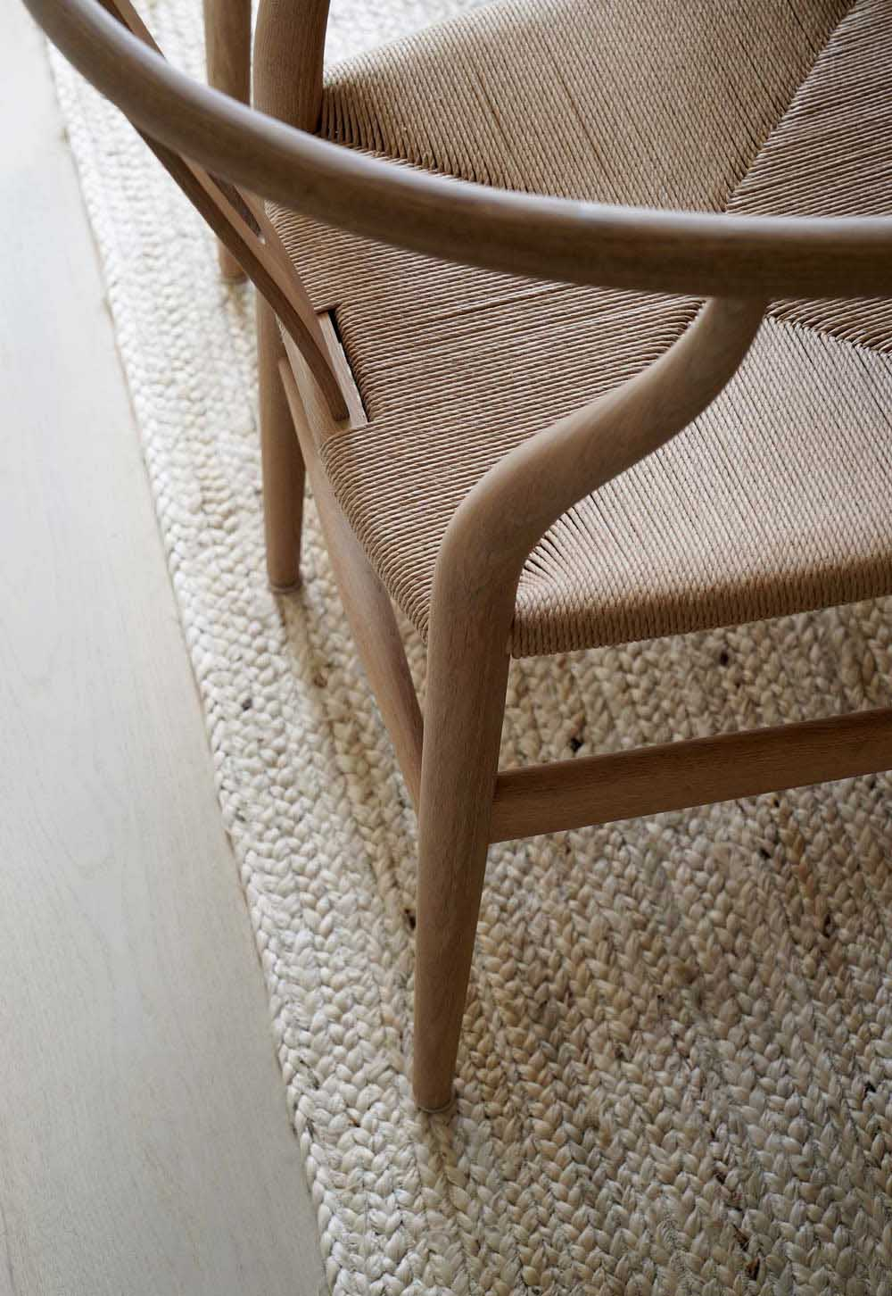 White-oiled oak Wishbone chair and jute rug in a rustic-minimalist cottage dining room | These Four Walls blog