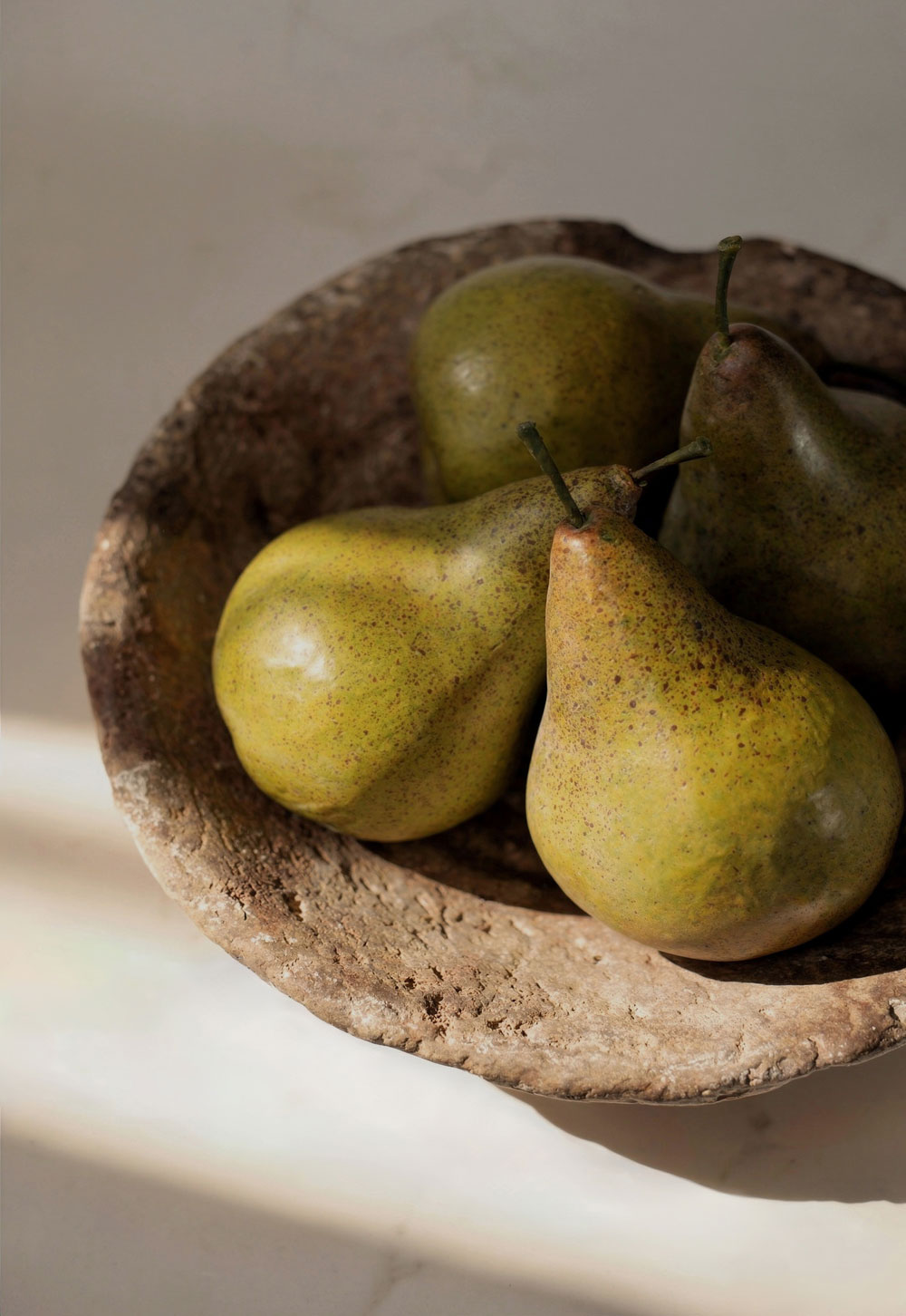 Pears and rustic stone bowl in a minimalist cottage kitchen | These Four Walls blog