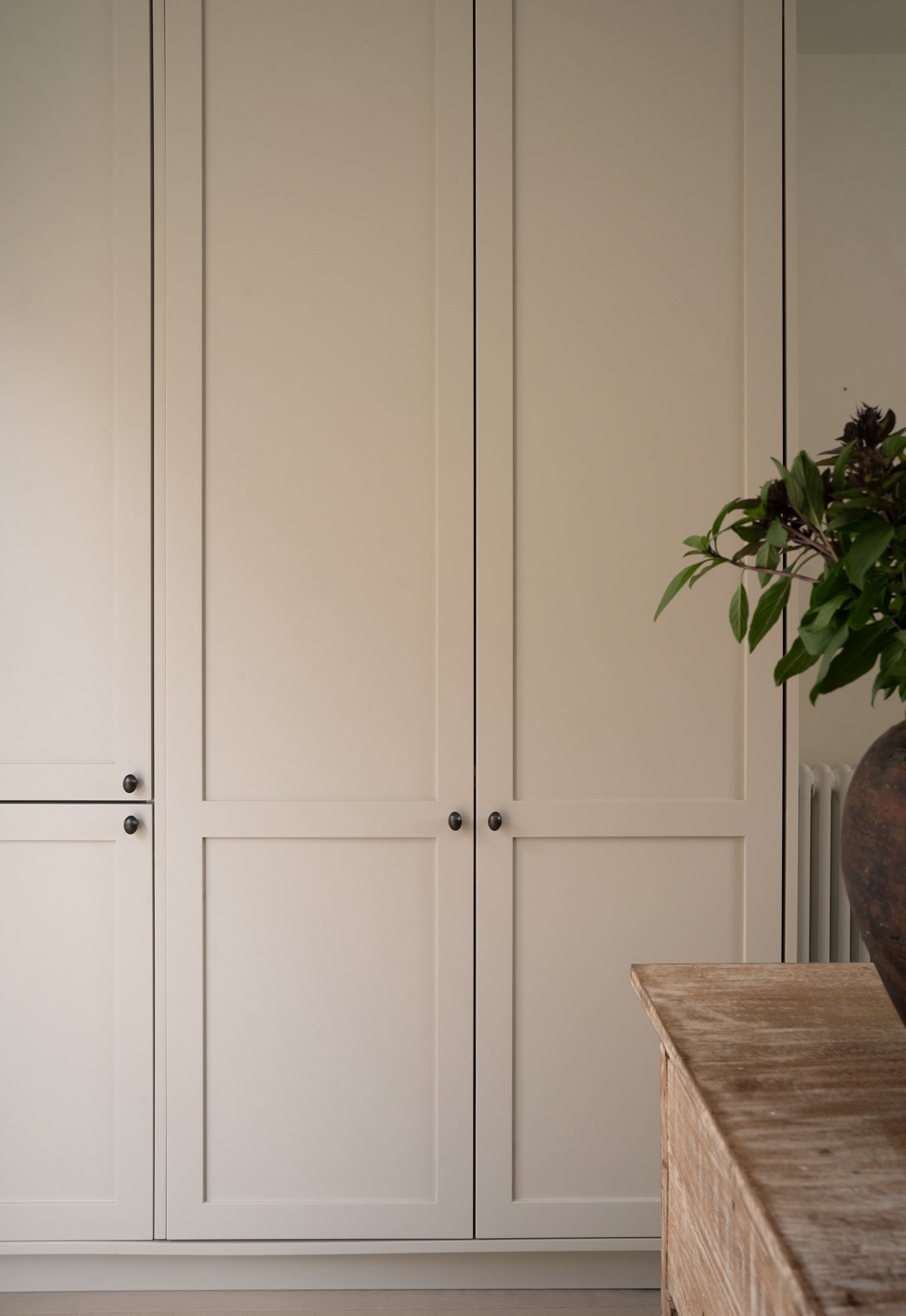 Beige Shaker units and freestanding wooden island unit in a minimalist cottage kitchen | These Four Walls blog