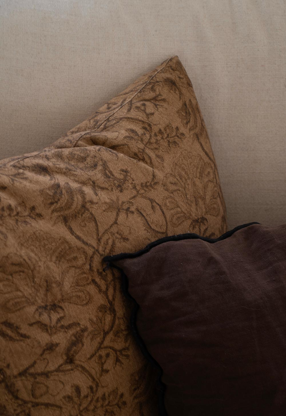 Brown floral-print cushion with faded tapestry effect on a beige linen sofa | These Four Walls blog